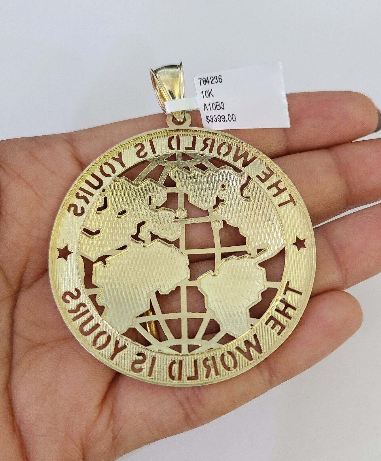 Side angle view of 10K gold "The World Is Yours" pendant on Franco chain
