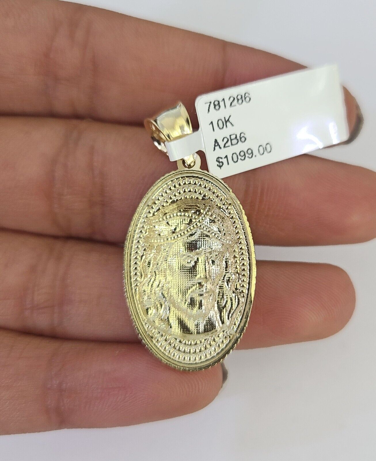 Full display of 10K yellow gold Franco chain with Jesus head pendant