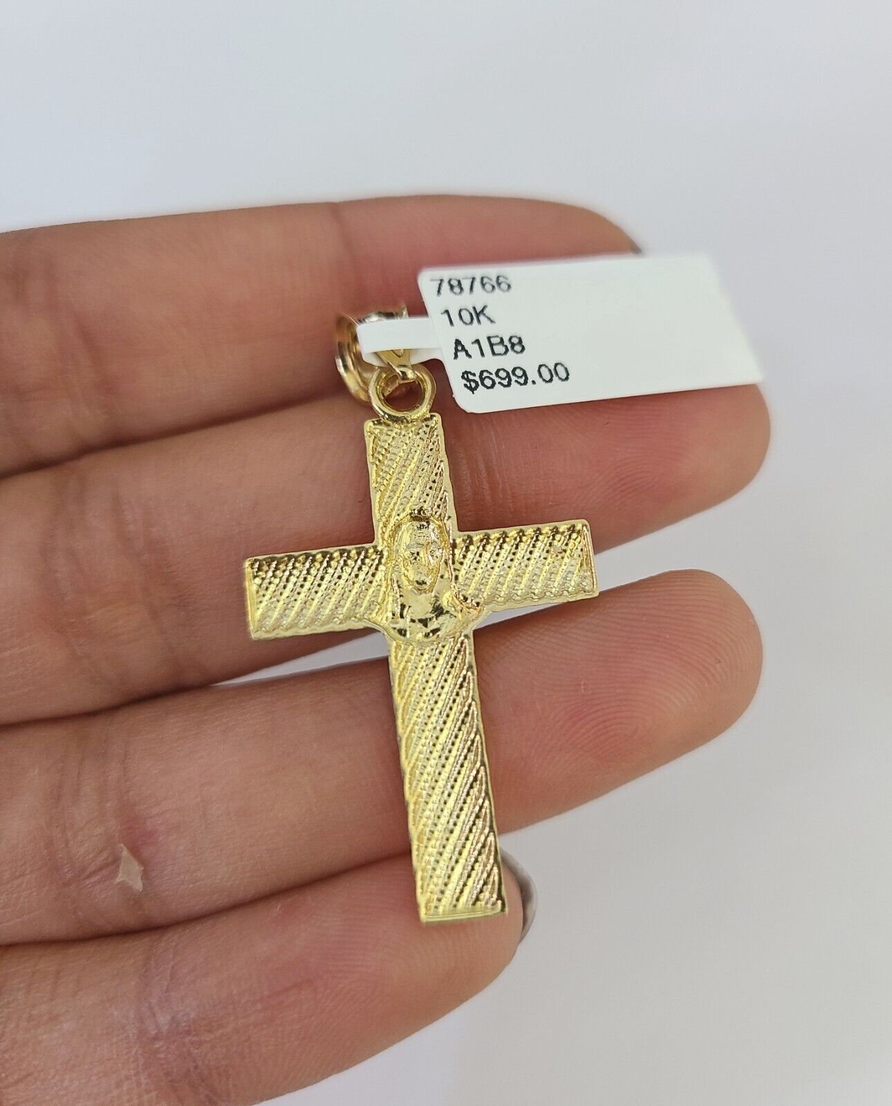 Close-up of 10K yellow gold Jesus cross pendant on Franco chain necklace