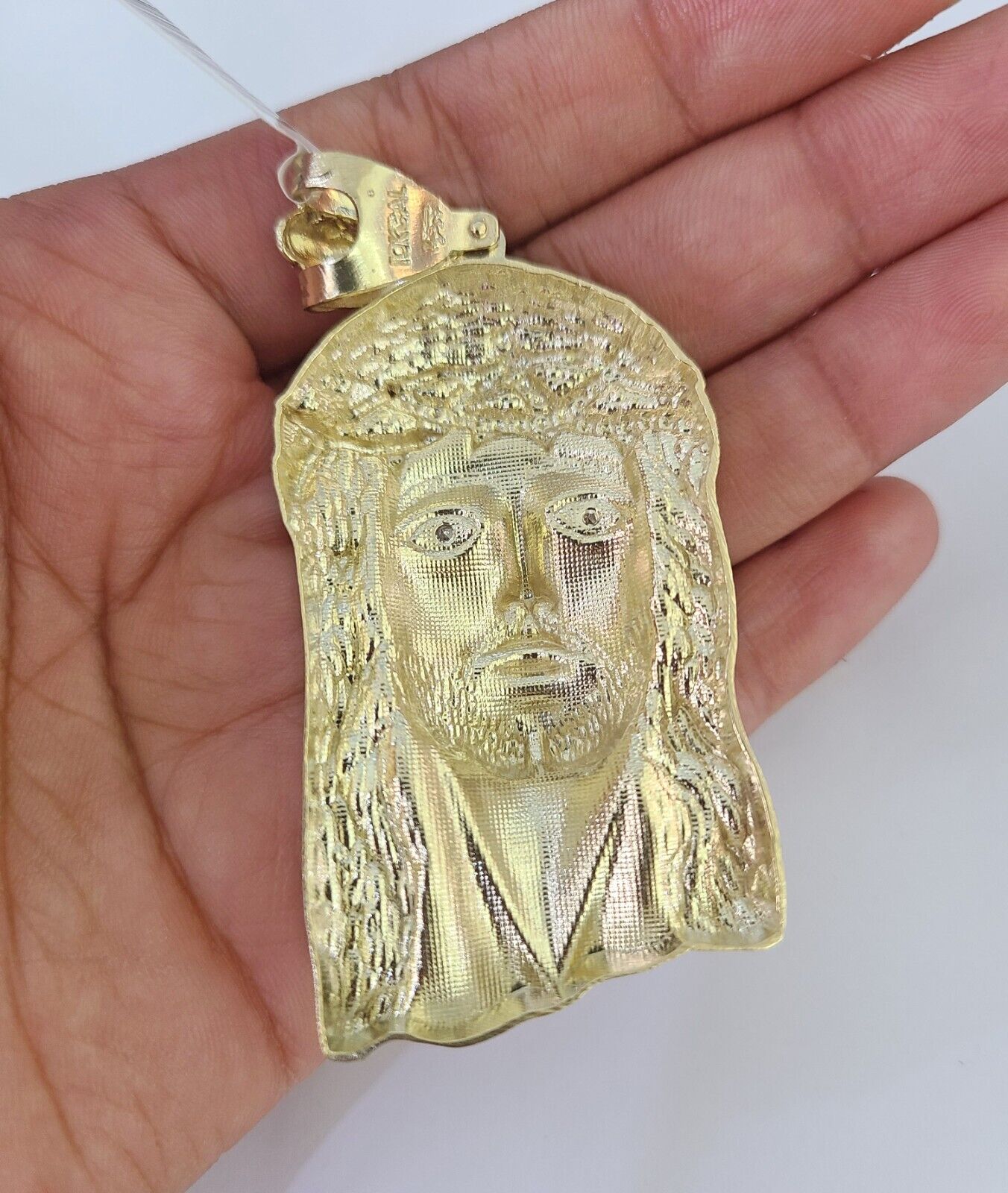 Side angle view of 10K yellow gold Jesus head pendant on Franco chain