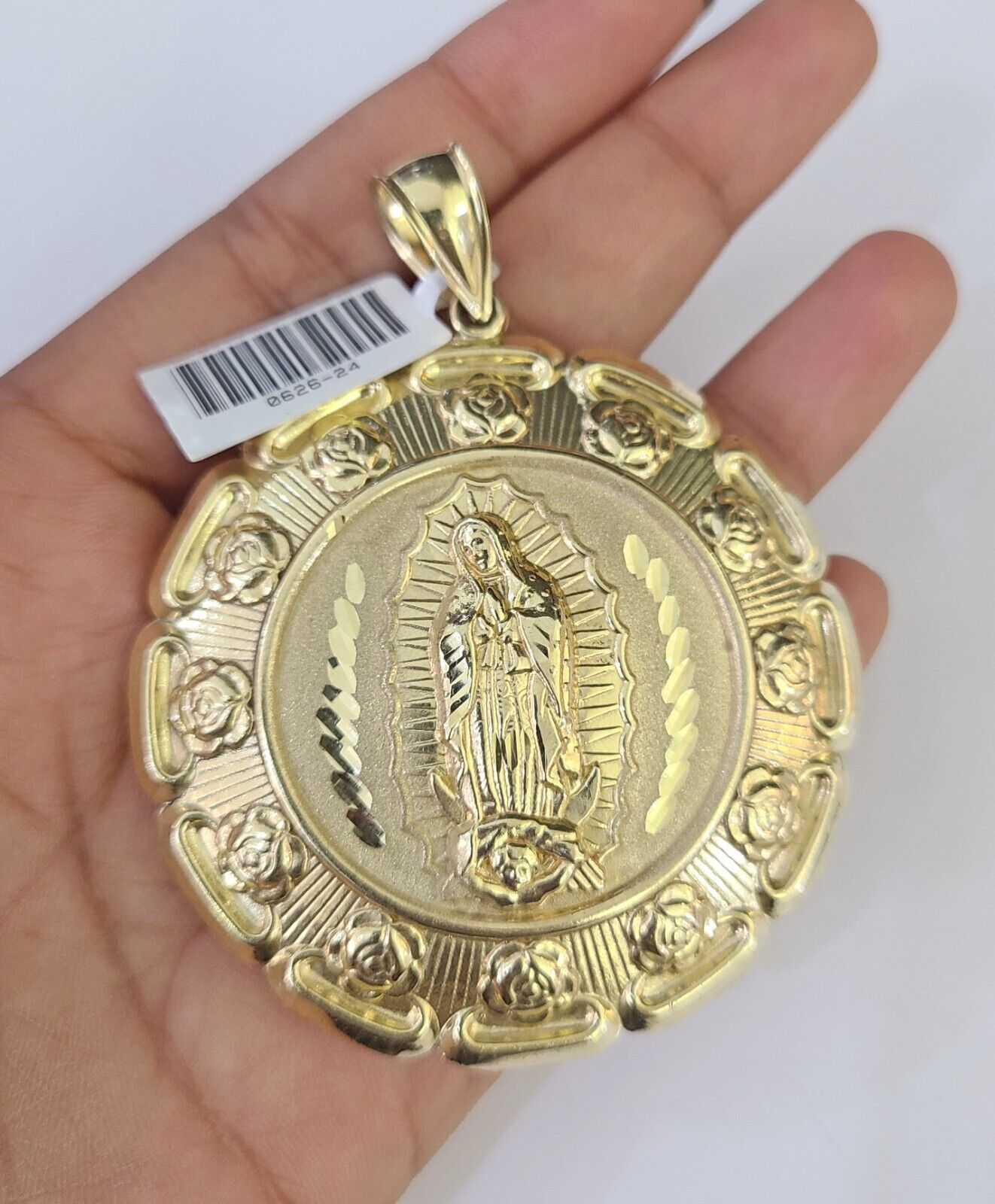 Close-up detailed view of 10K yellow gold Jesus and Mary pendant charm