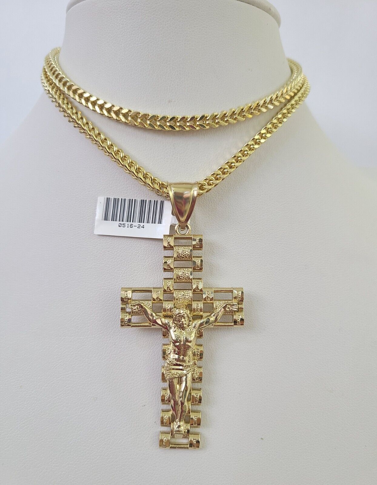 Flat lay display of Reva Jeweler 10K yellow gold crucifix necklace set