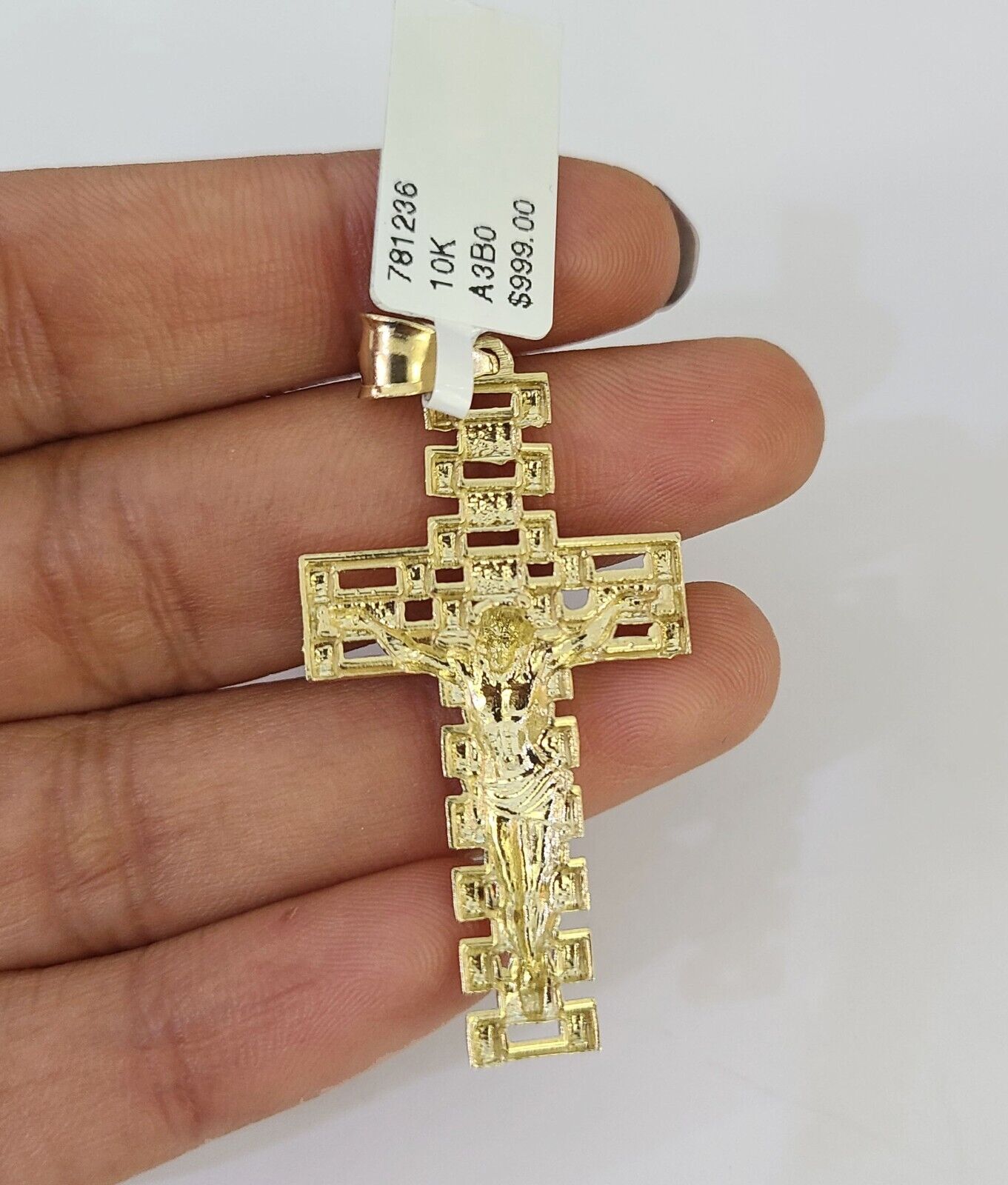 Close-up of 10K yellow gold Jesus cross pendant on Franco chain necklace