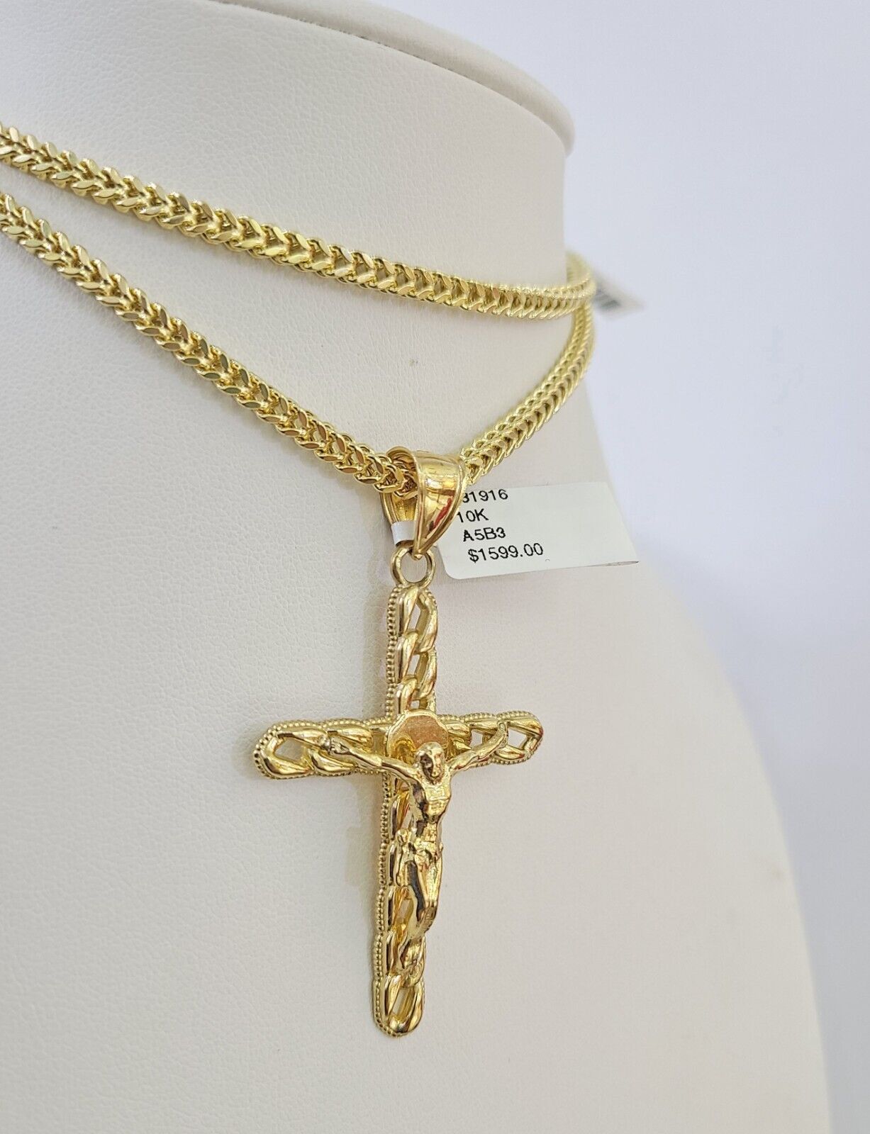 Close-up detail of Jesus cross pendant jewelry in 10K gold