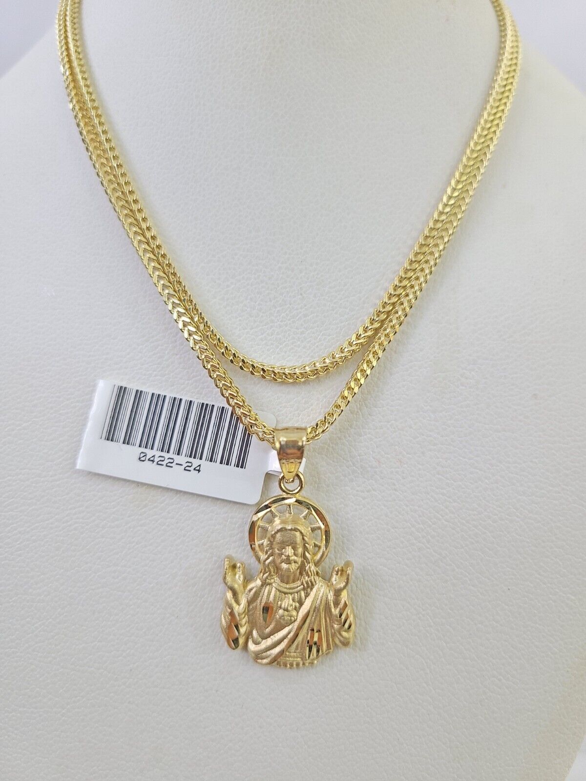 Flat lay display of Reva Jeweler 10K yellow gold Jesus necklace set