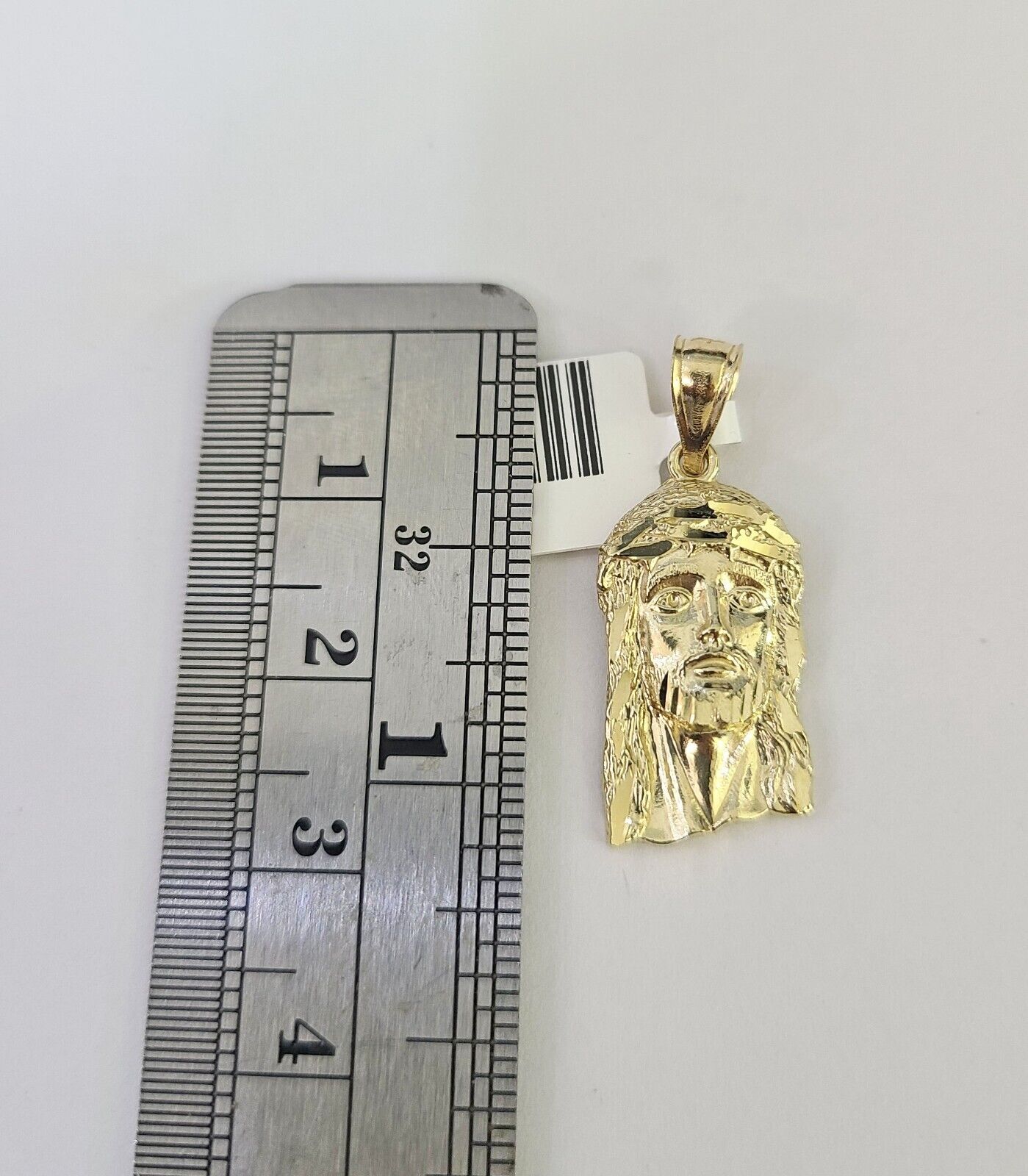 Flat lay display of Reva Jeweler 10K yellow gold Jesus head necklace set