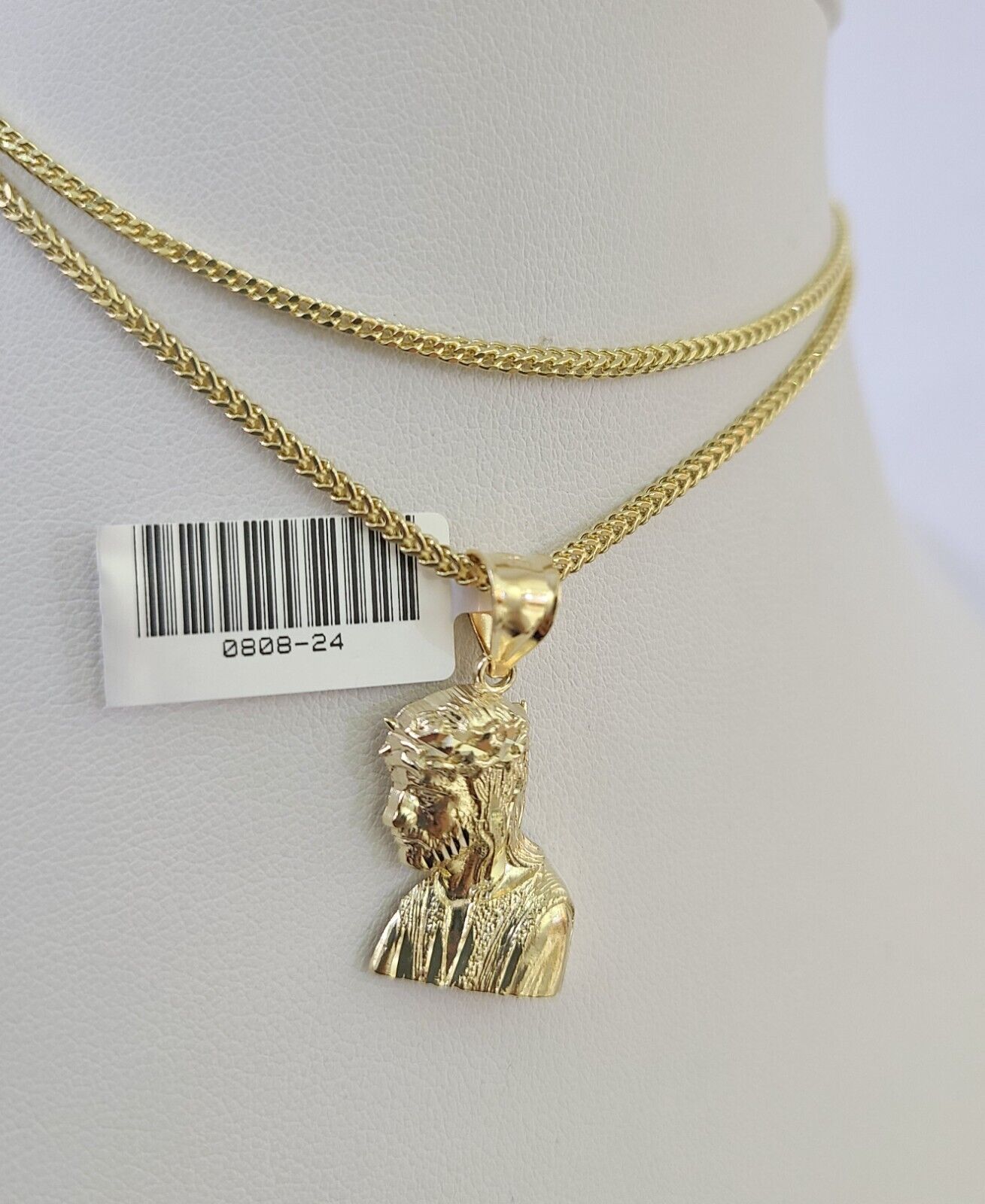 Full display of 10K yellow gold Franco chain with Jesus head pendant