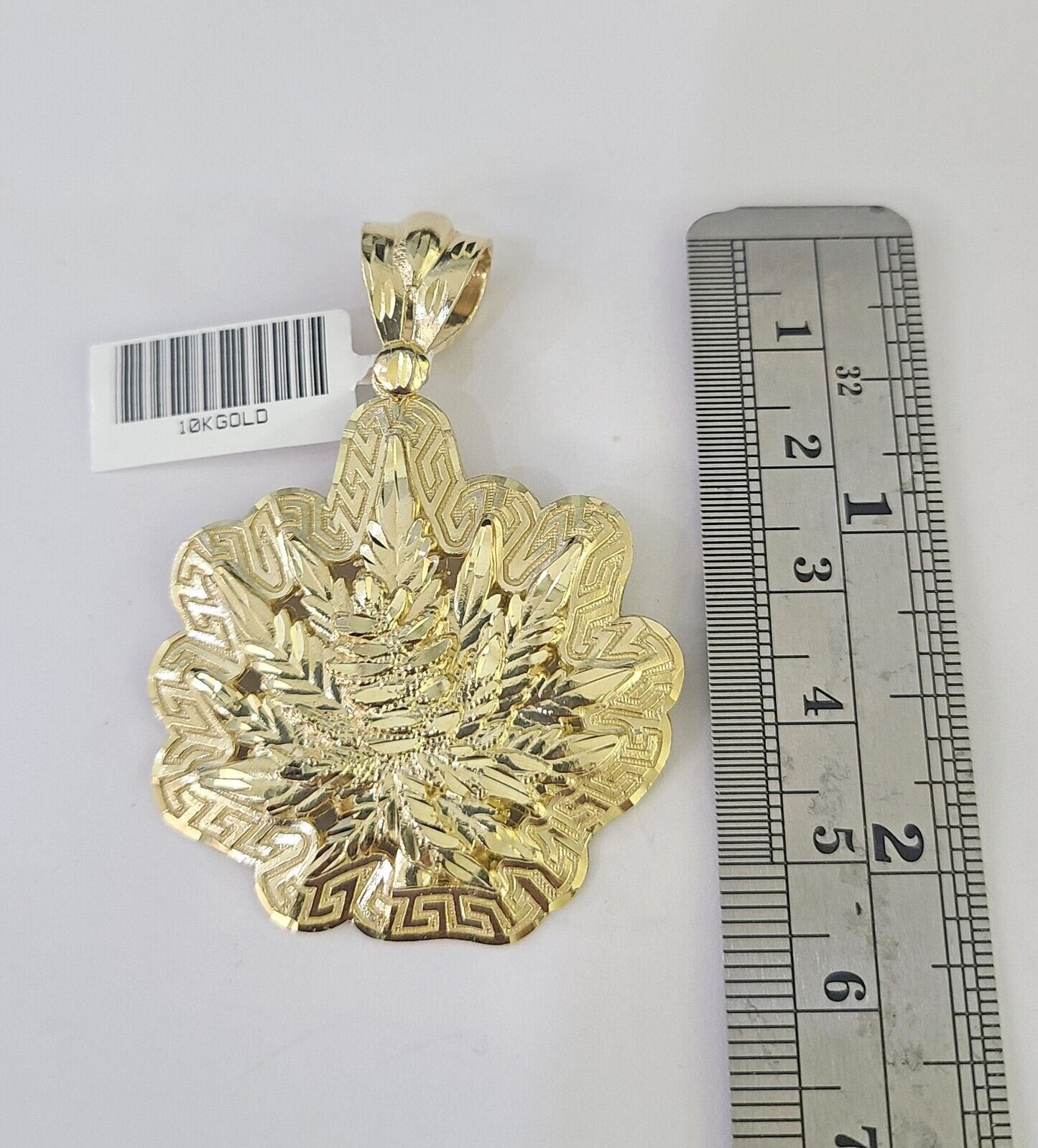 Flat lay display of Reva Jeweler 10K yellow gold tree leaf necklace set
