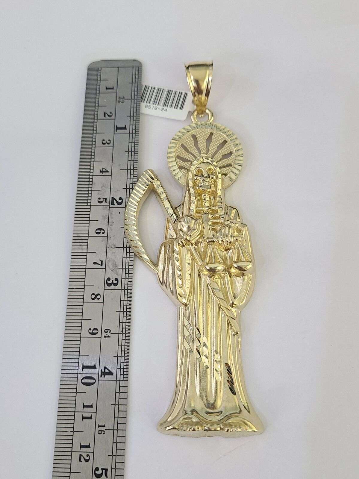 Flat lay display of Reva Jeweler 10K yellow gold Saint Reaper necklace set