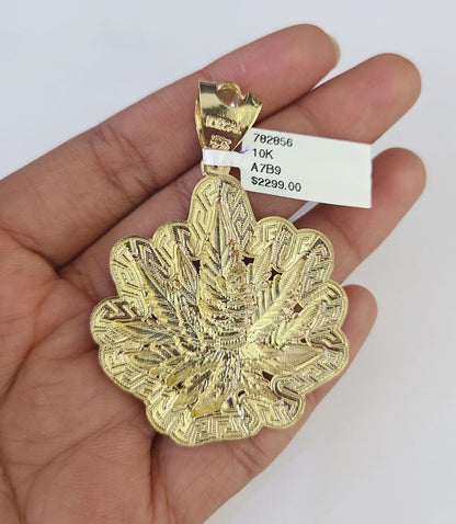 Side angle view of 10K yellow gold weed leaf pendant on Franco chain
