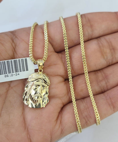 Flat lay display of Reva Jeweler 10K yellow gold Jesus head necklace set