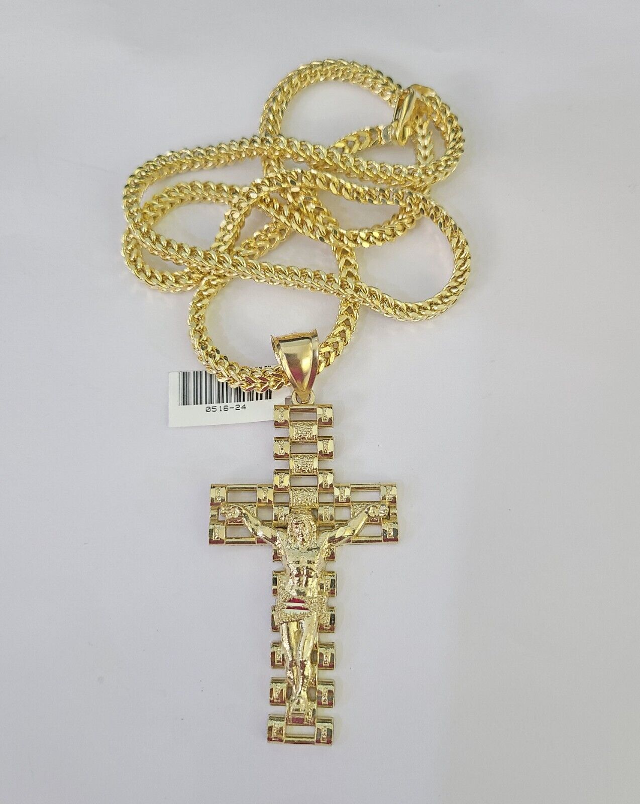 Side angle view of 10K yellow gold Jesus crucifix pendant on Franco chain