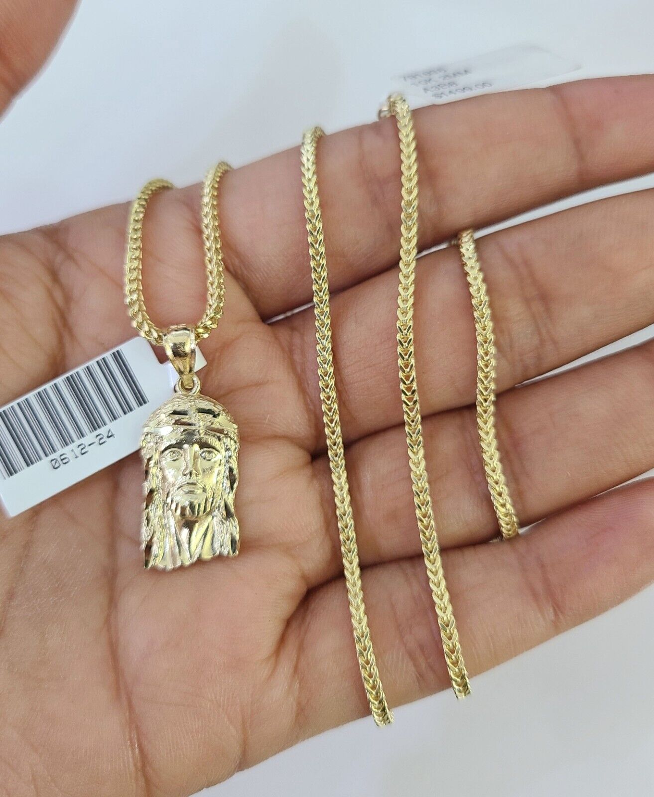 Full display of 10K yellow gold Franco chain with Jesus head pendant