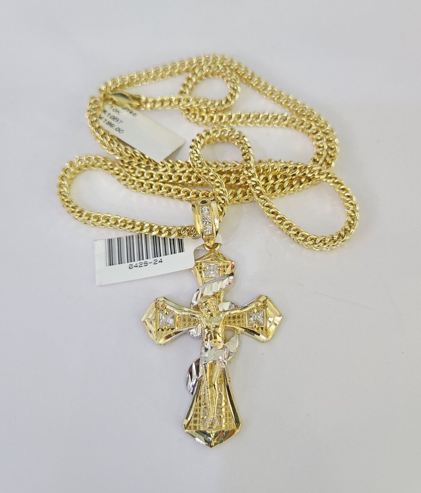 Close-up of 10K yellow gold Jesus cross pendant on Franco chain necklace