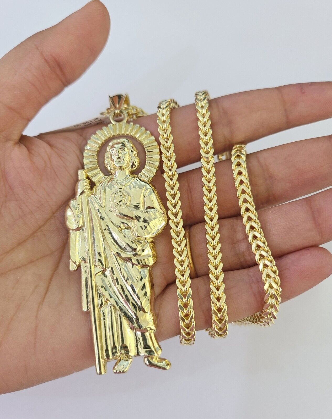Flat lay display of Reva Jeweler 10K yellow gold Saint Jude necklace set