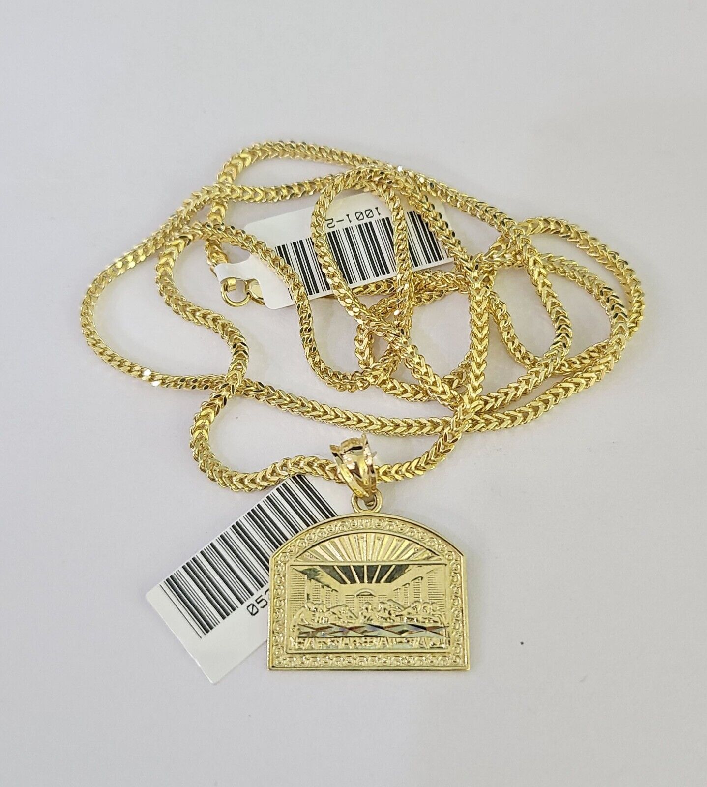 Side angle view of 10K yellow gold Last Supper pendant on Franco chain