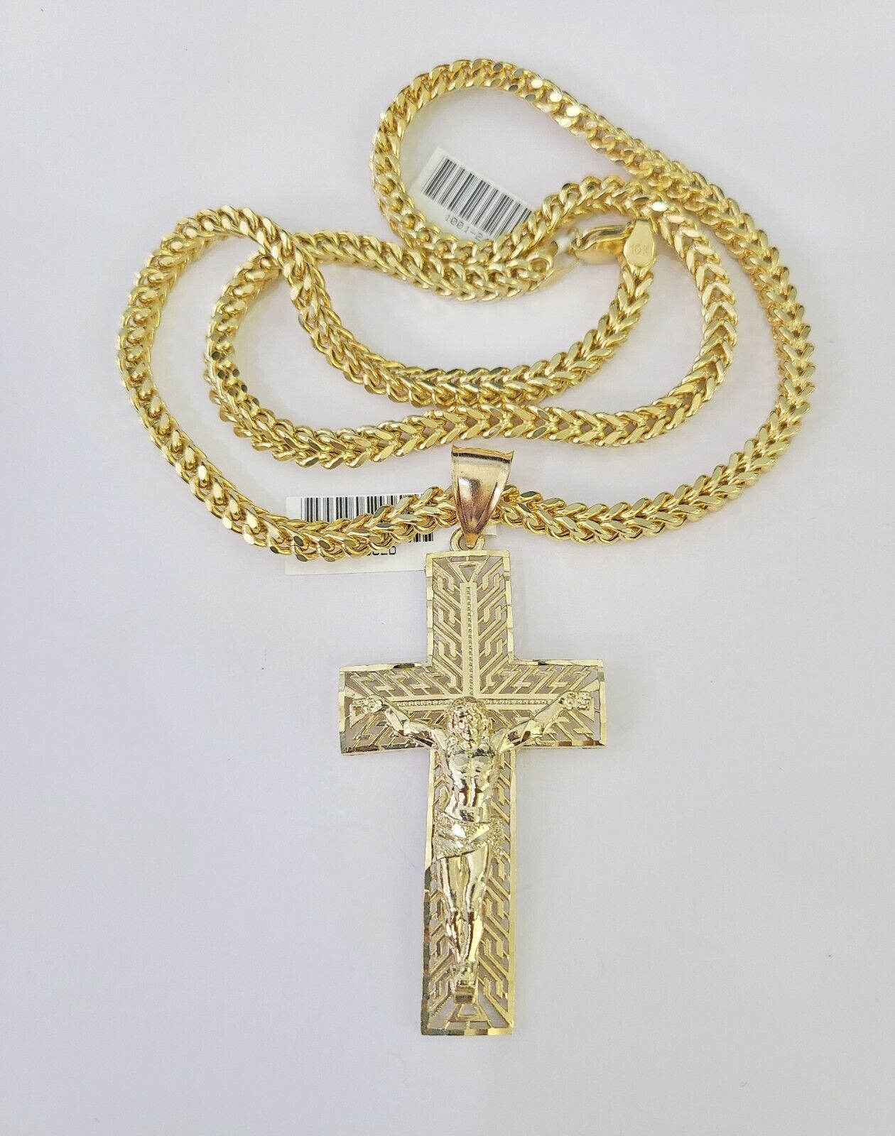 Flat lay view of 10K yellow gold Franco chain and Jesus cross pendant set