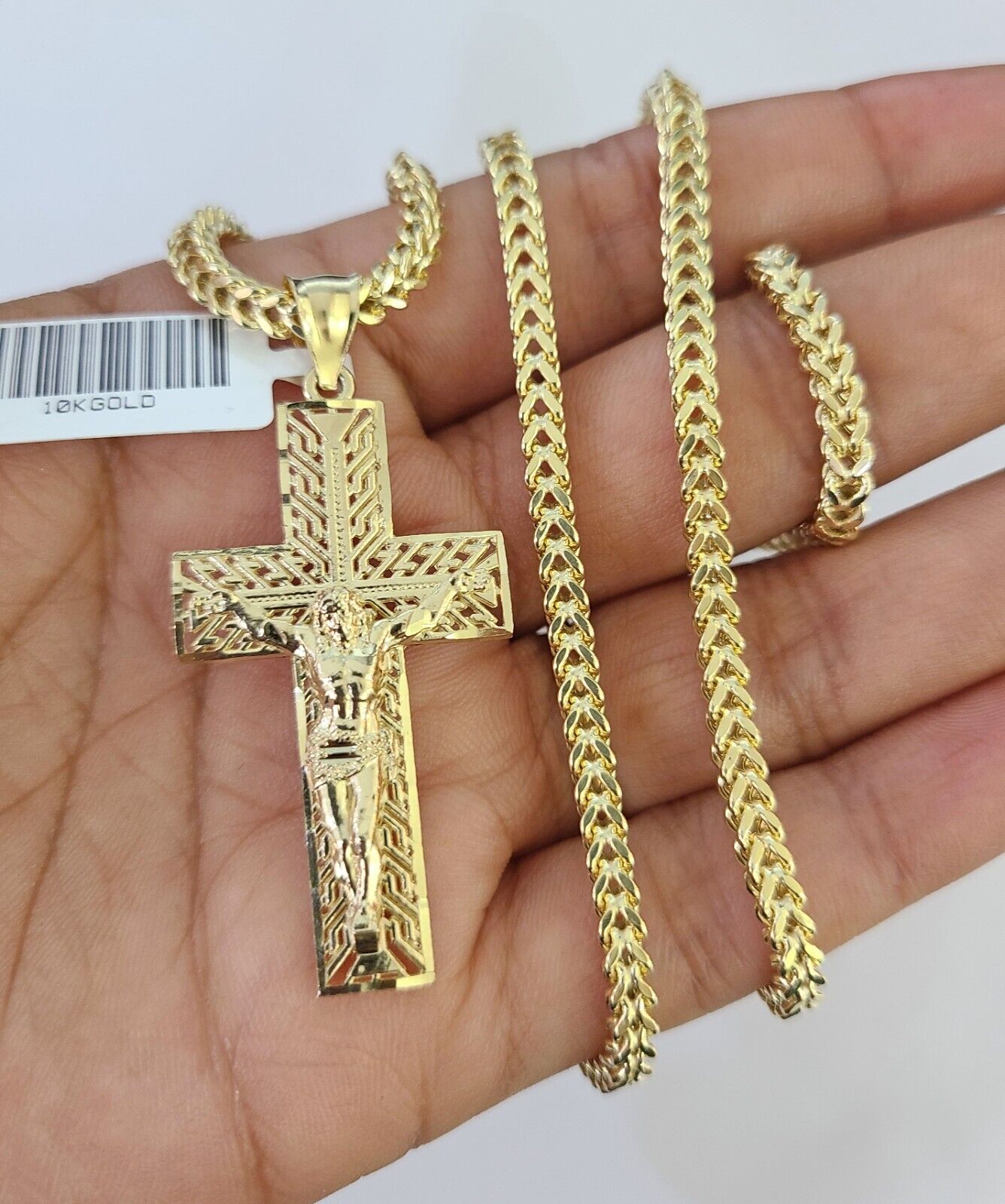 Close-up of 10K yellow gold Jesus cross pendant on Franco chain necklace