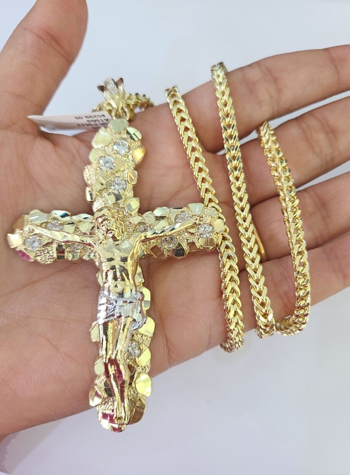 Flat lay display of Reva Jeweler 10K yellow gold crucifix necklace set