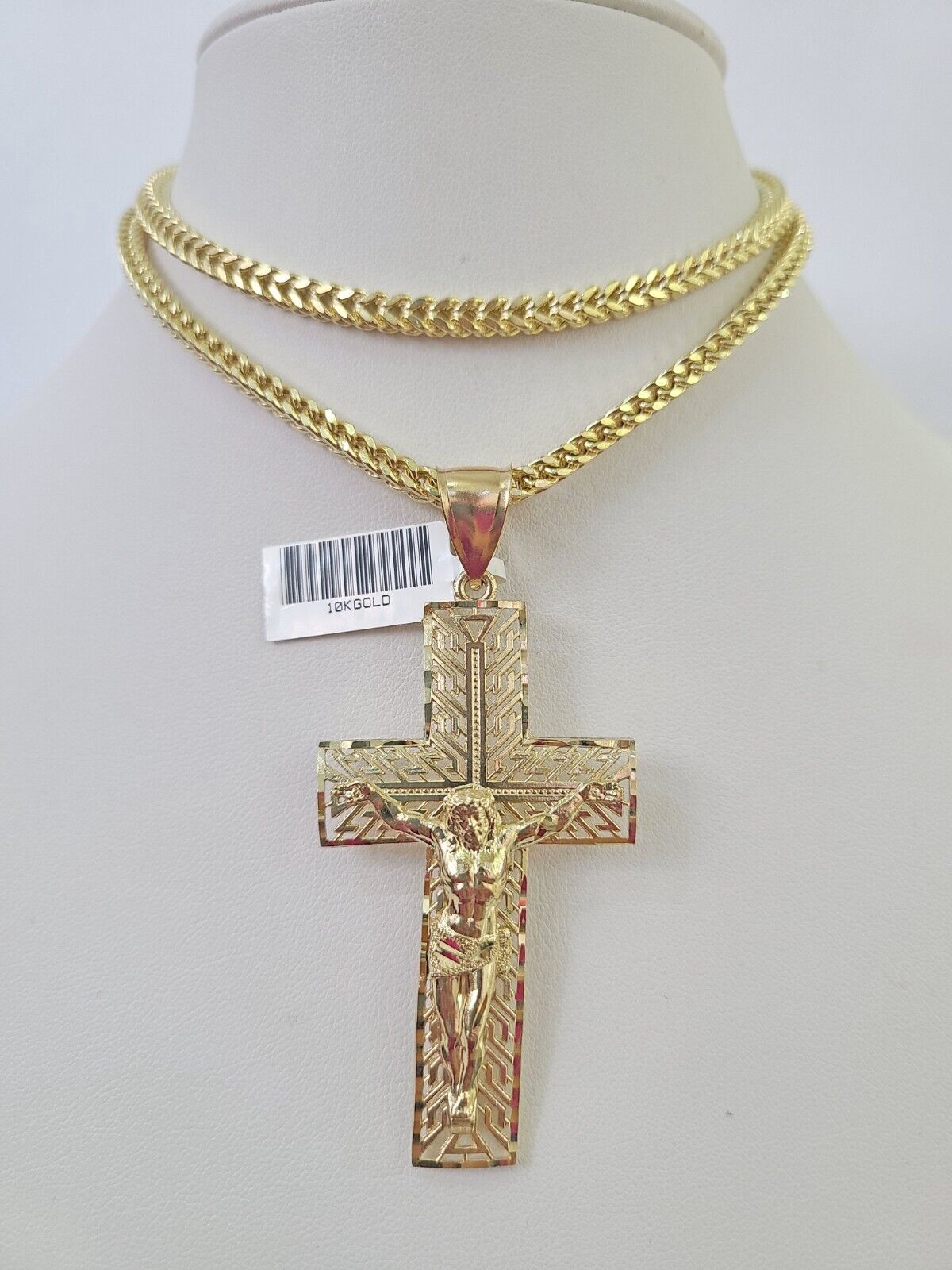 Flat lay display of Reva Jeweler 10K yellow gold crucifix necklace set