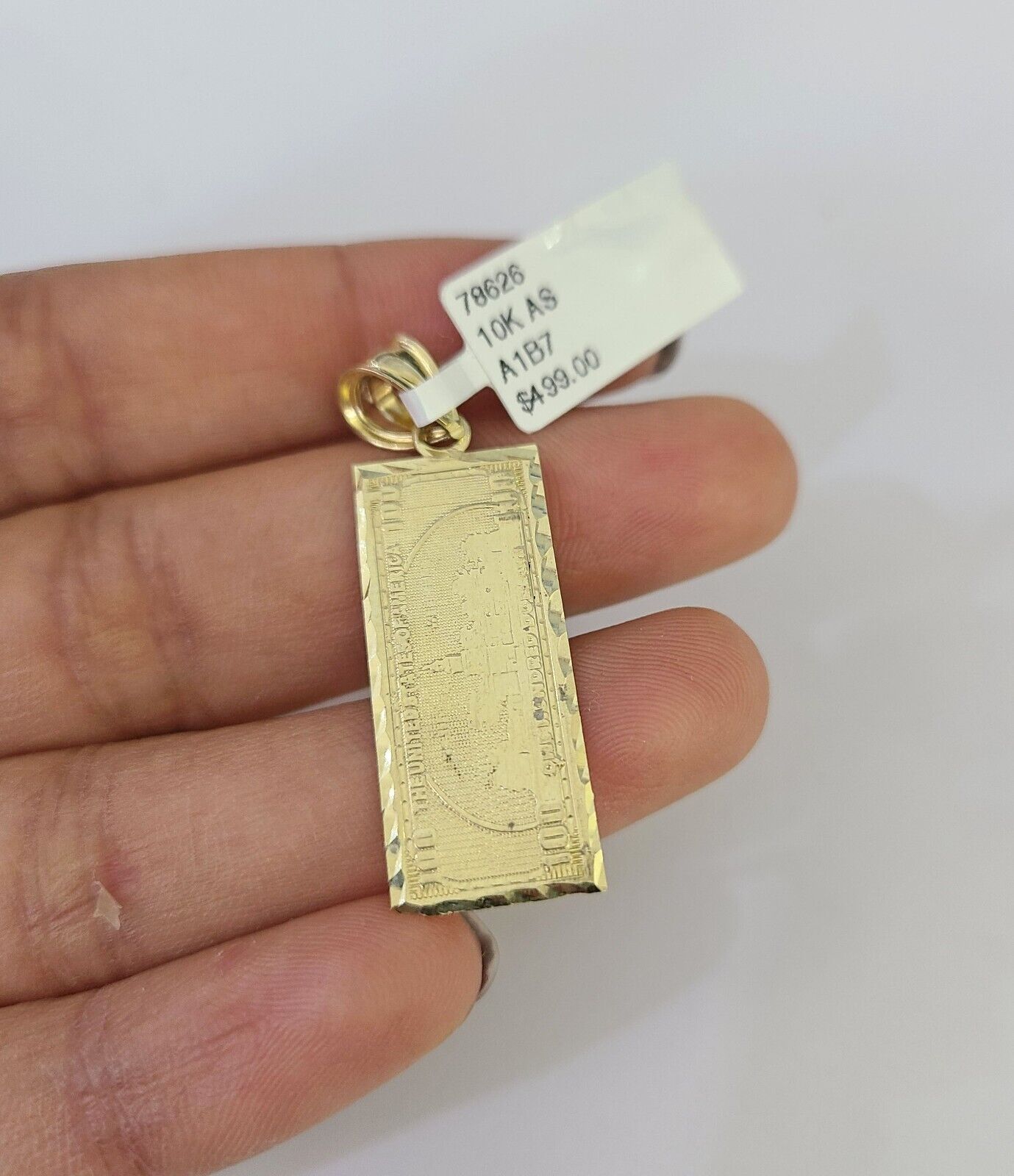 Close-up of 10K gold money dollar pendant on Franco chain necklace