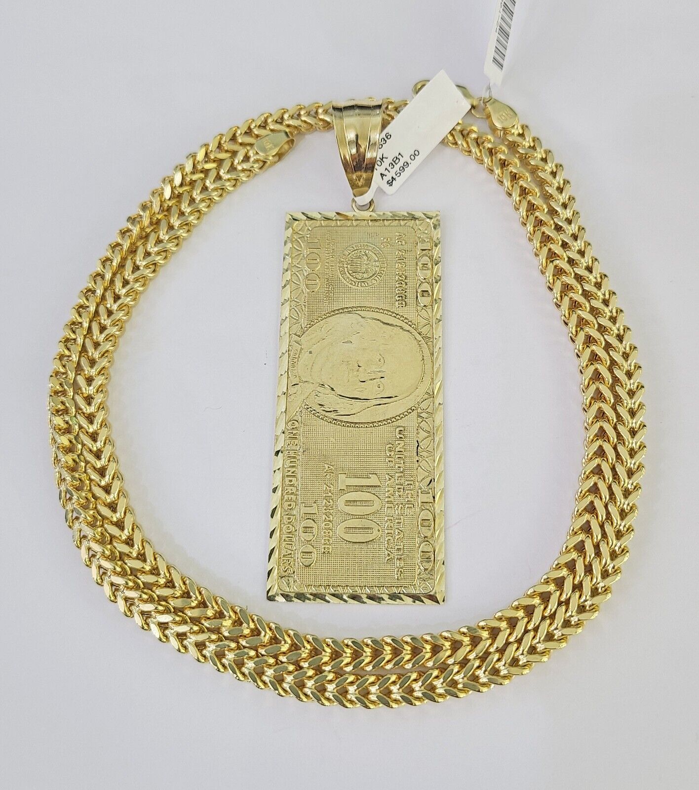 Close-up of 10K gold dollar money pendant on Franco chain necklace