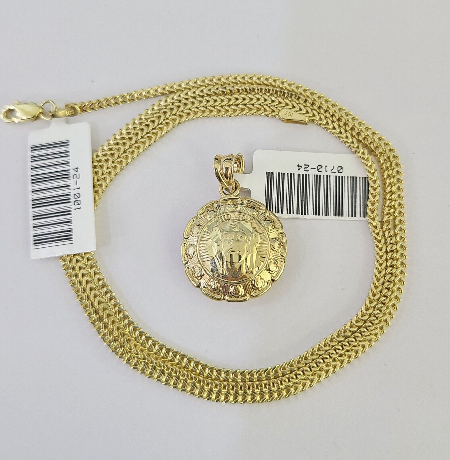Side angle view of 10K yellow gold Jesus and Mary pendant on Franco chain