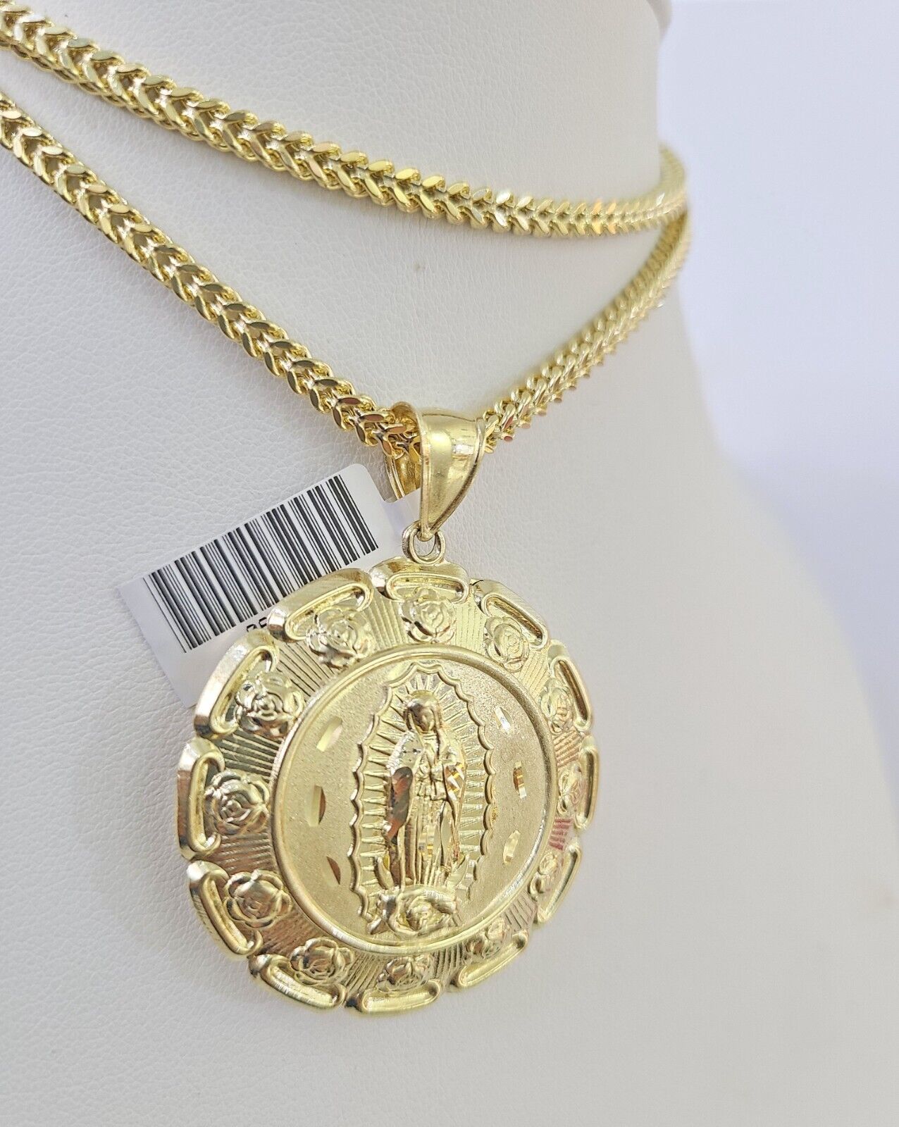 Close-up detailed view of 10K yellow gold Jesus and Mary pendant charm