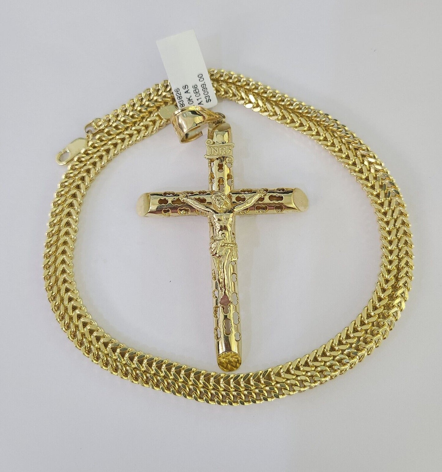 Flat lay display of Reva Jeweler 10K yellow gold INRI cross necklace set