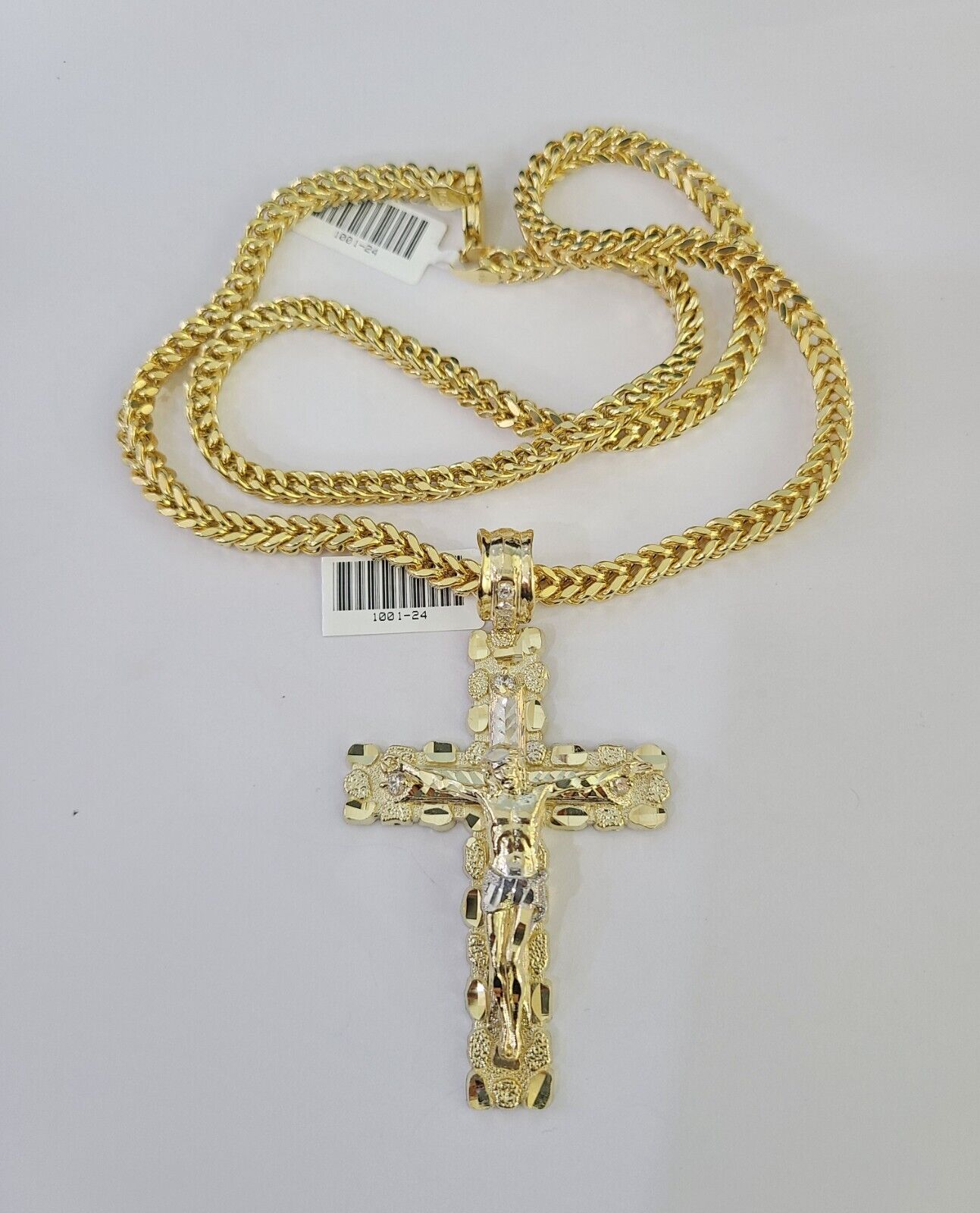 Side angle view of 10K yellow gold Jesus cross pendant on Franco chain