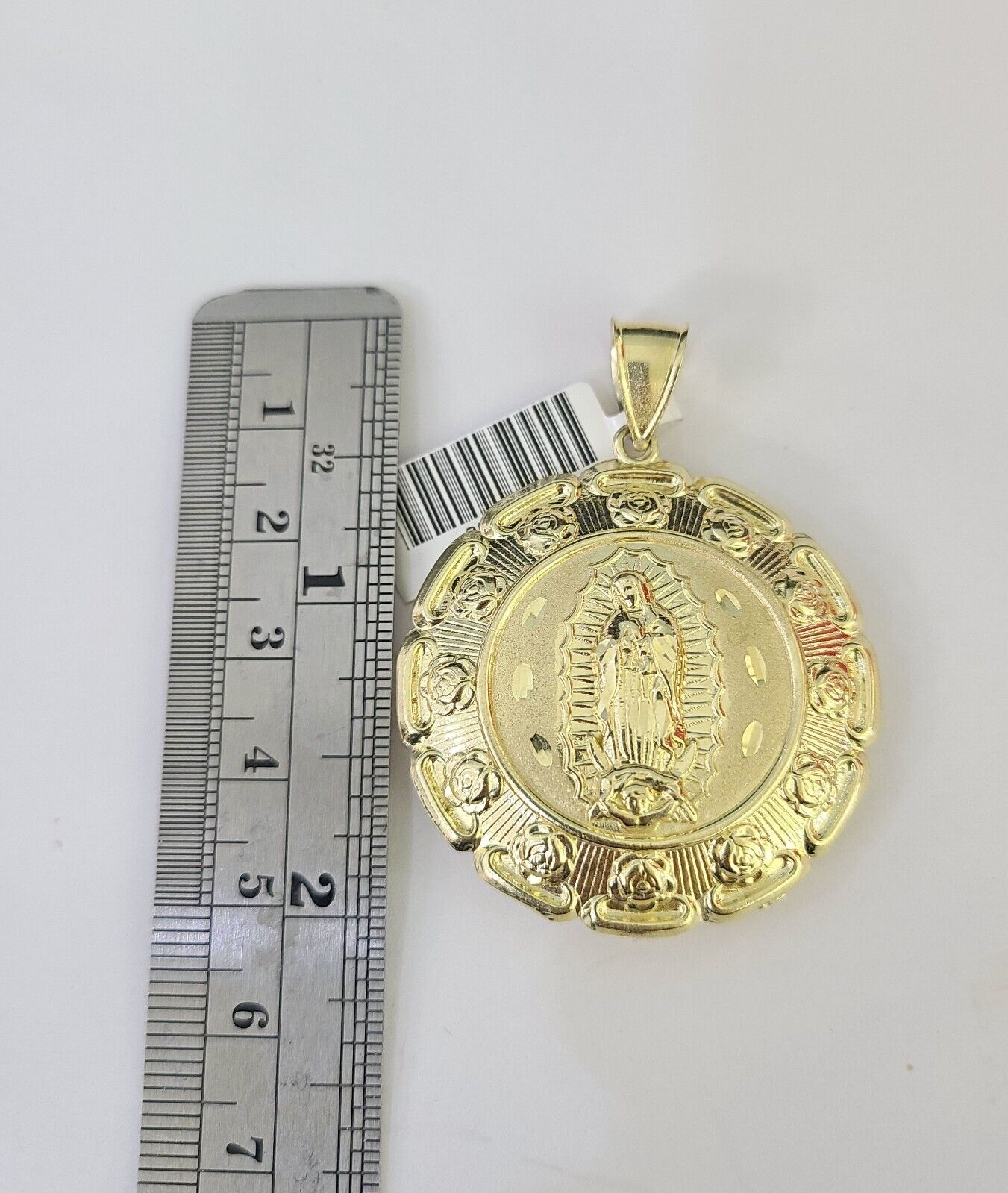 Side angle view of 10K yellow gold Jesus and Mary pendant on Franco chain