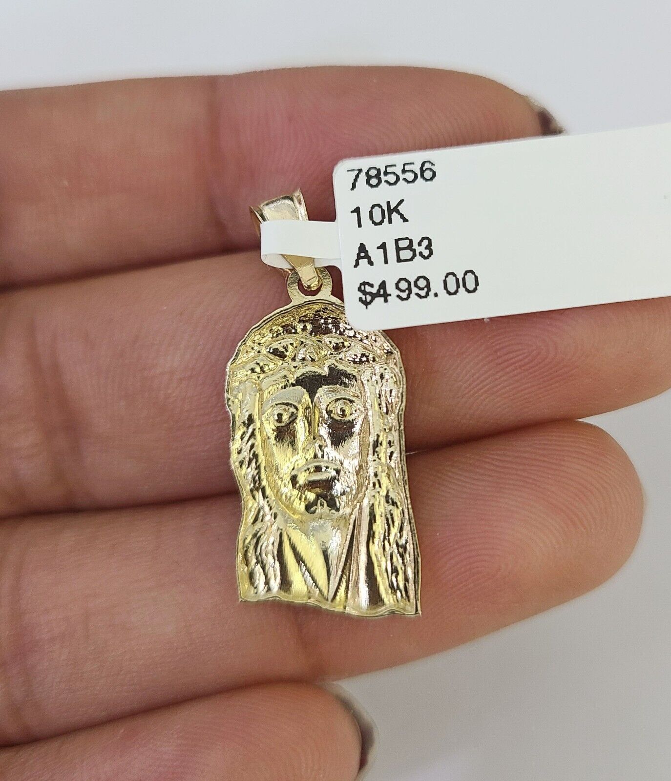 Side angle view of 10K yellow gold Jesus head pendant on Franco chain