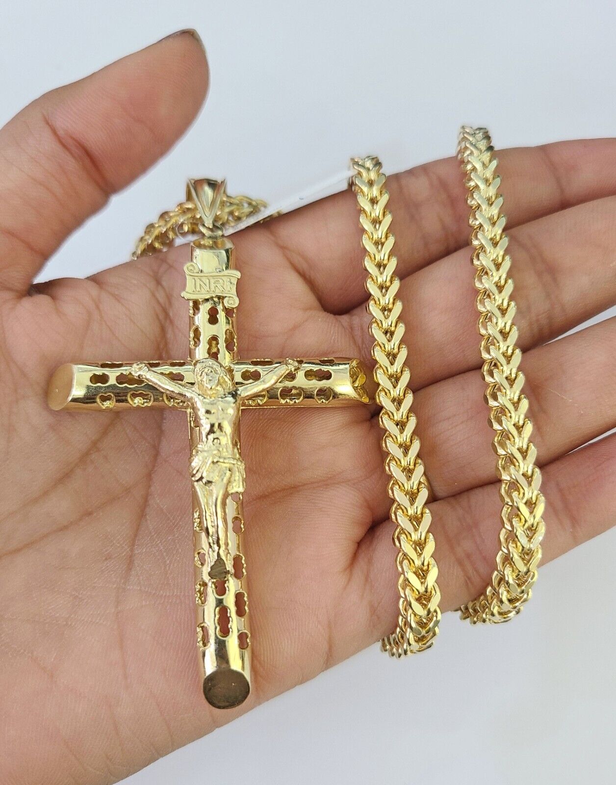 Close-up of 10K yellow gold INRI Jesus cross pendant on Franco chain necklace