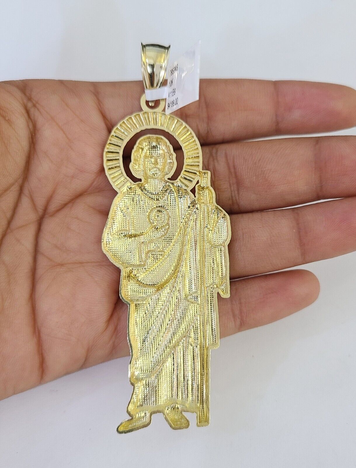 Flat lay display of Reva Jeweler 10K yellow gold Saint Jude necklace set