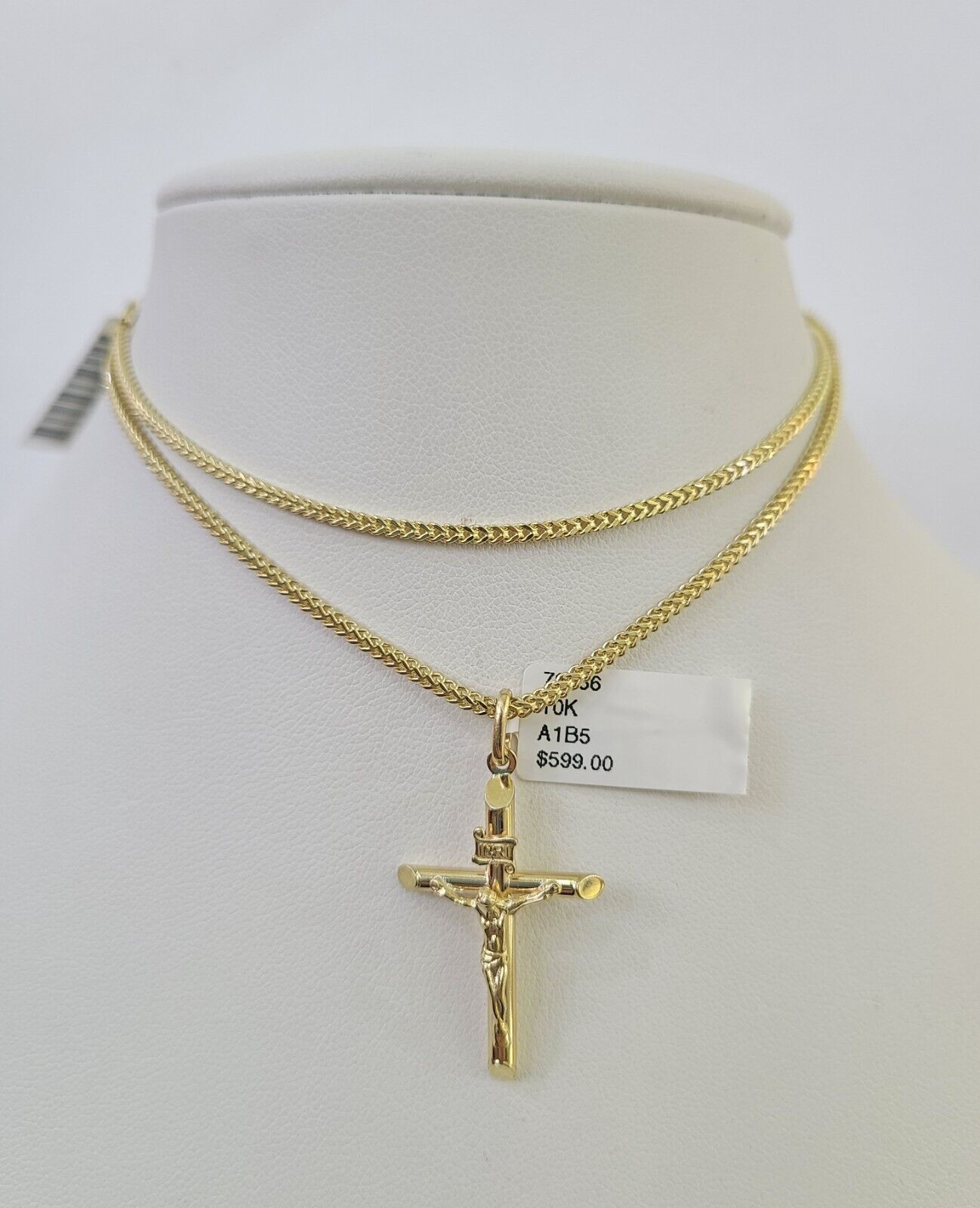 Close-up of 10K yellow gold INRI Jesus cross pendant on Franco chain necklace