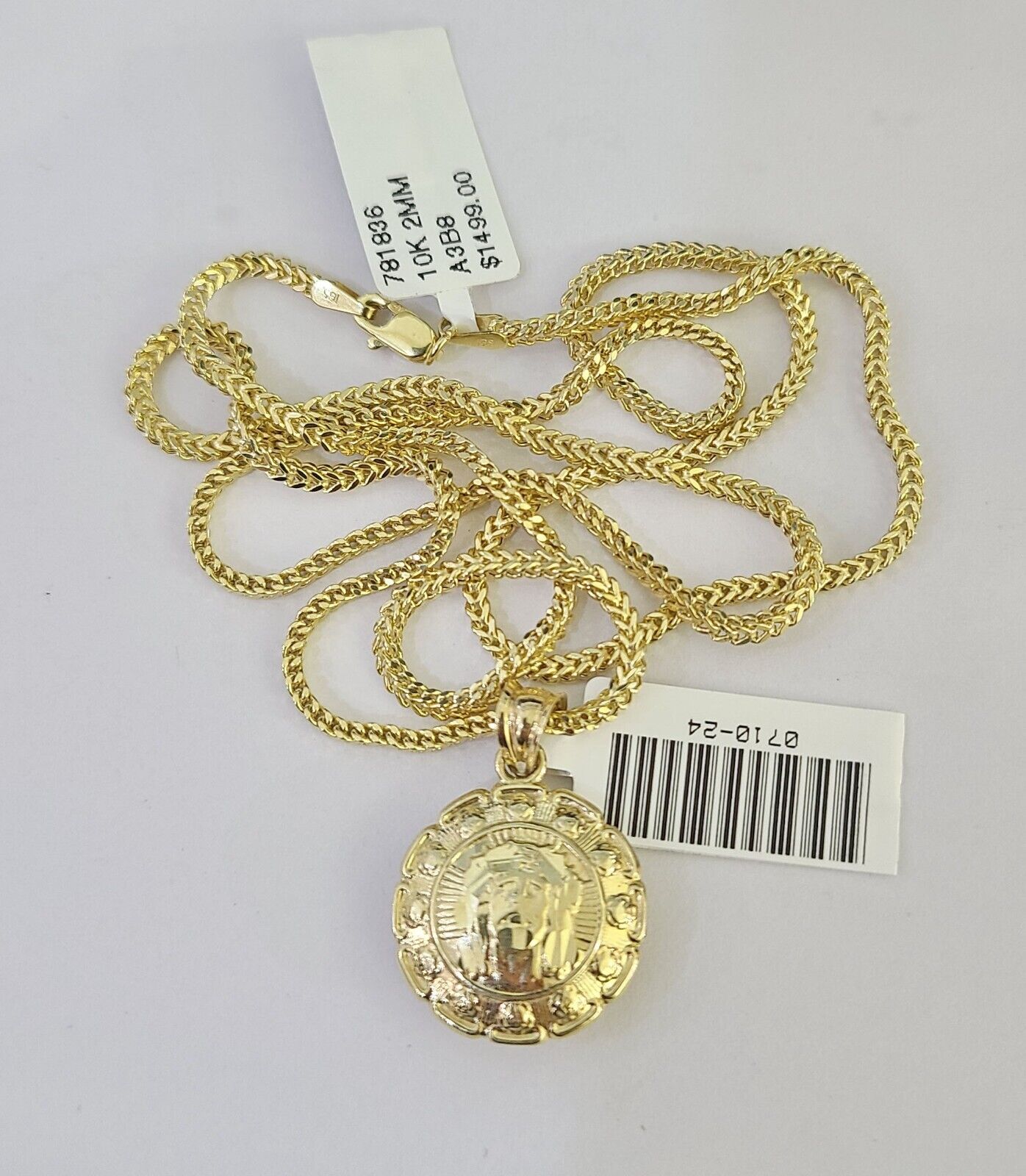 Close-up detailed view of 10K yellow gold Jesus and Mary pendant charm