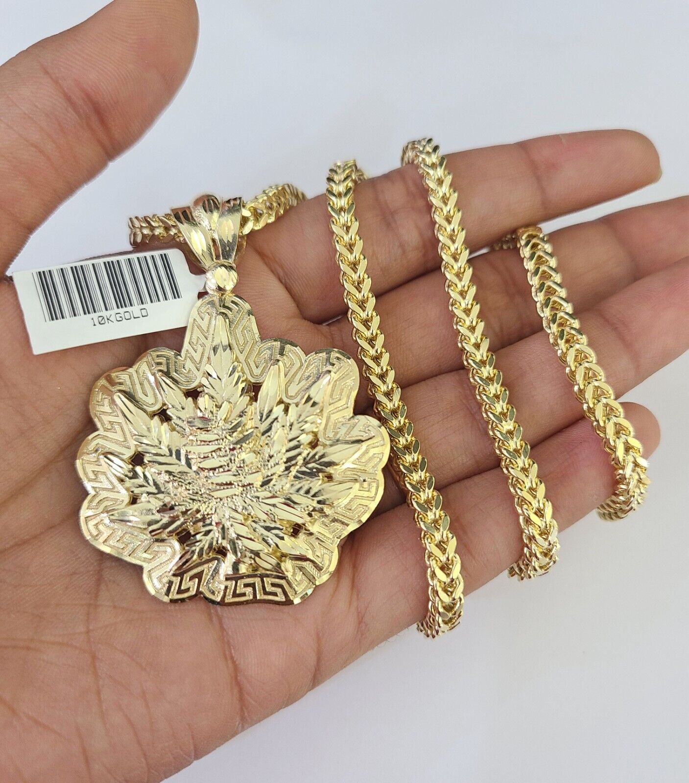 Flat lay display of Reva Jeweler 10K yellow gold weed leaf necklace set