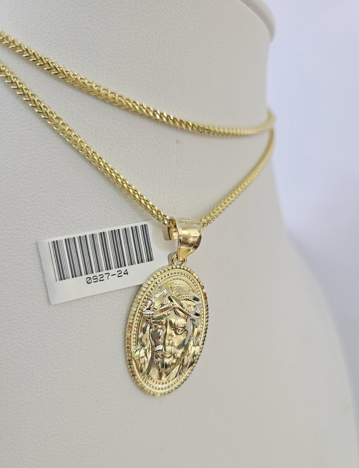 Flat lay display of Reva Jeweler 10K yellow gold Jesus head necklace set