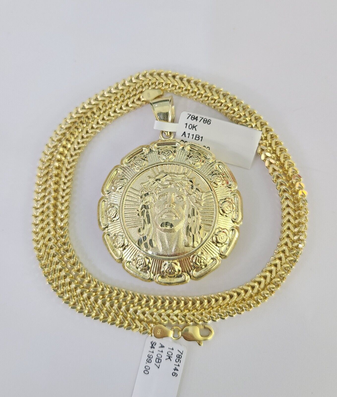 Flat lay display of Reva Jeweler 10K yellow gold Jesus and Mary necklace set