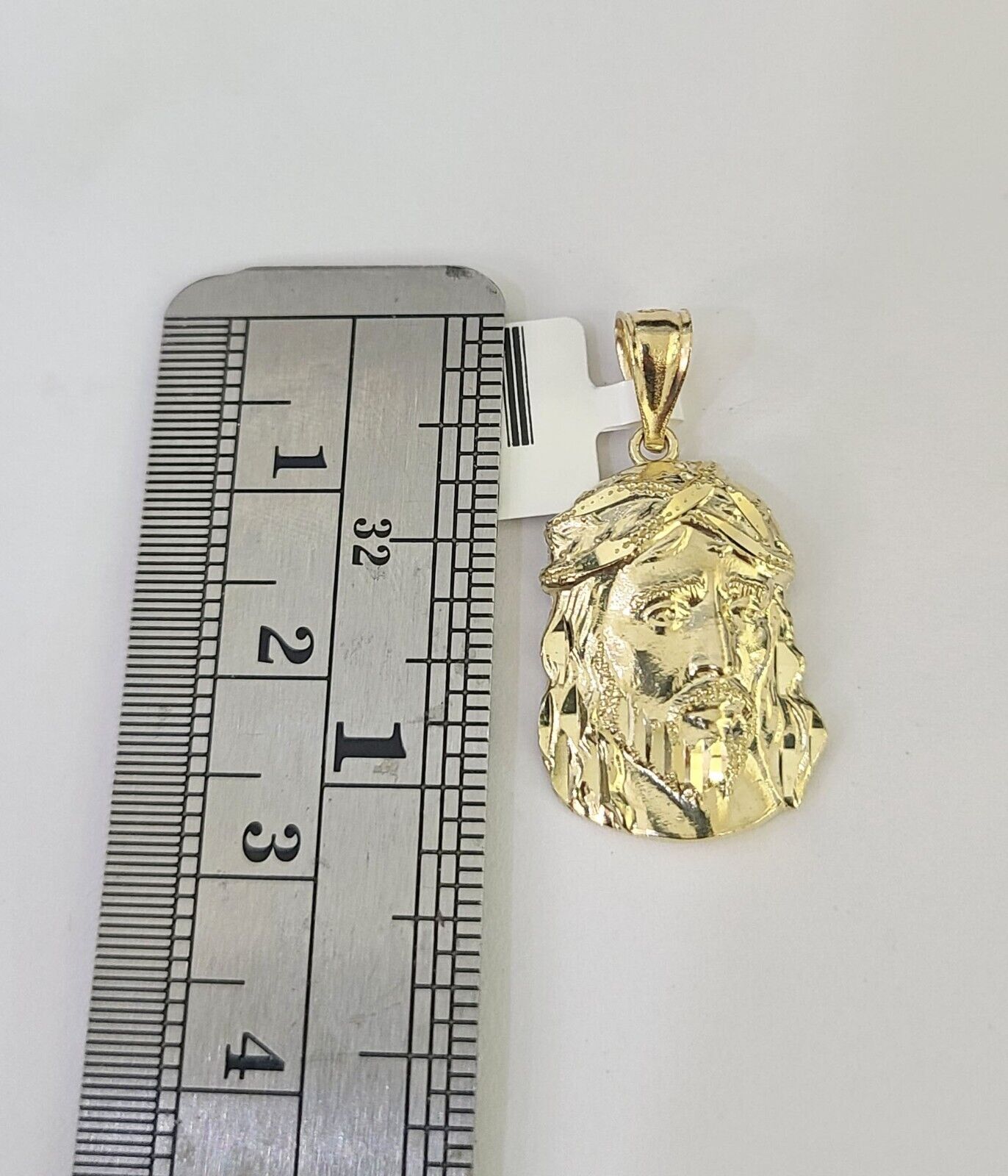 Front-facing view of Reva Jeweler 10K gold Jesus head pendant and chain