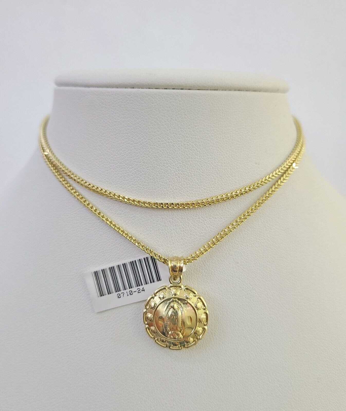 Flat lay display of Reva Jeweler 10K yellow gold Jesus and Mary necklace set