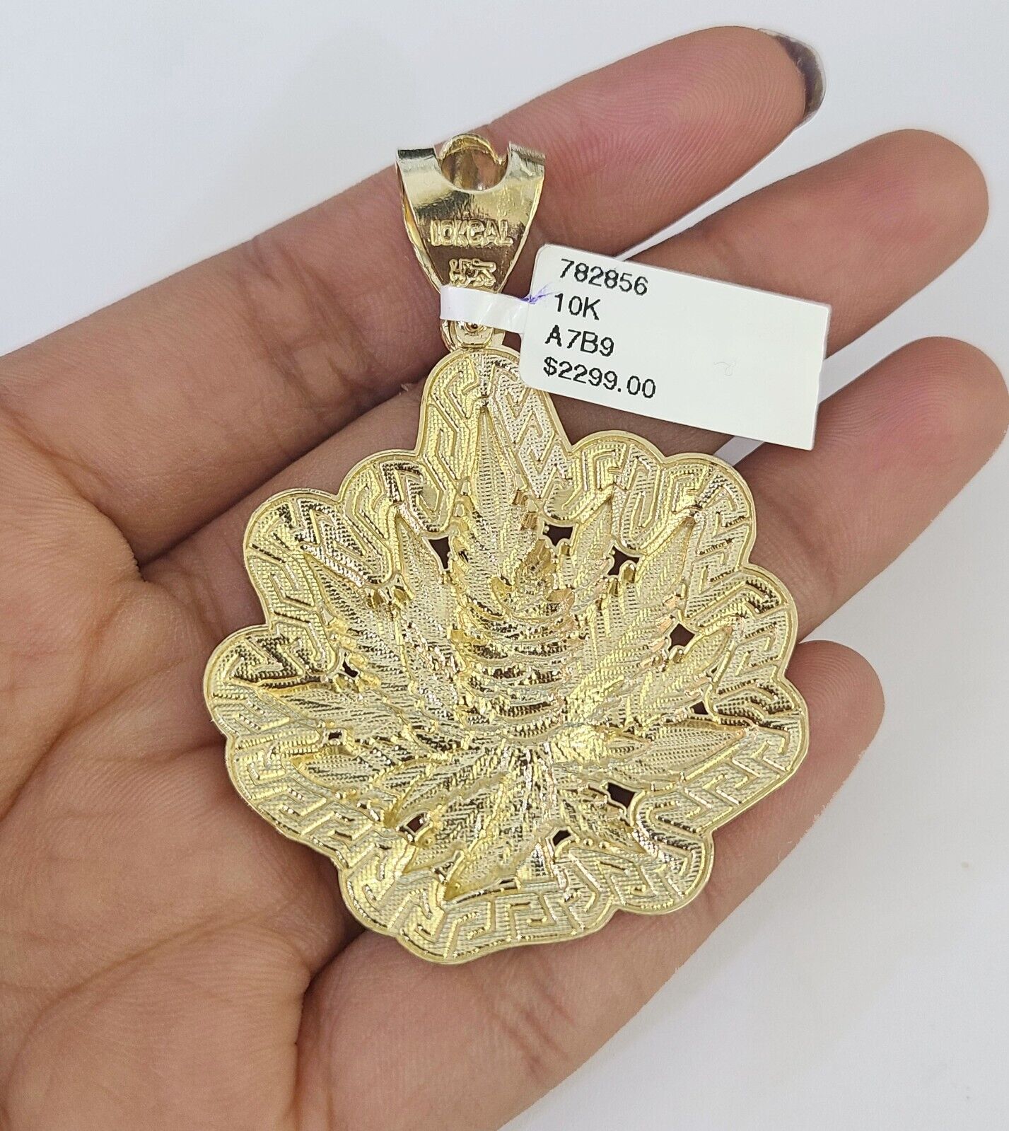Side angle view of 10K yellow gold tree leaf pendant on Franco chain